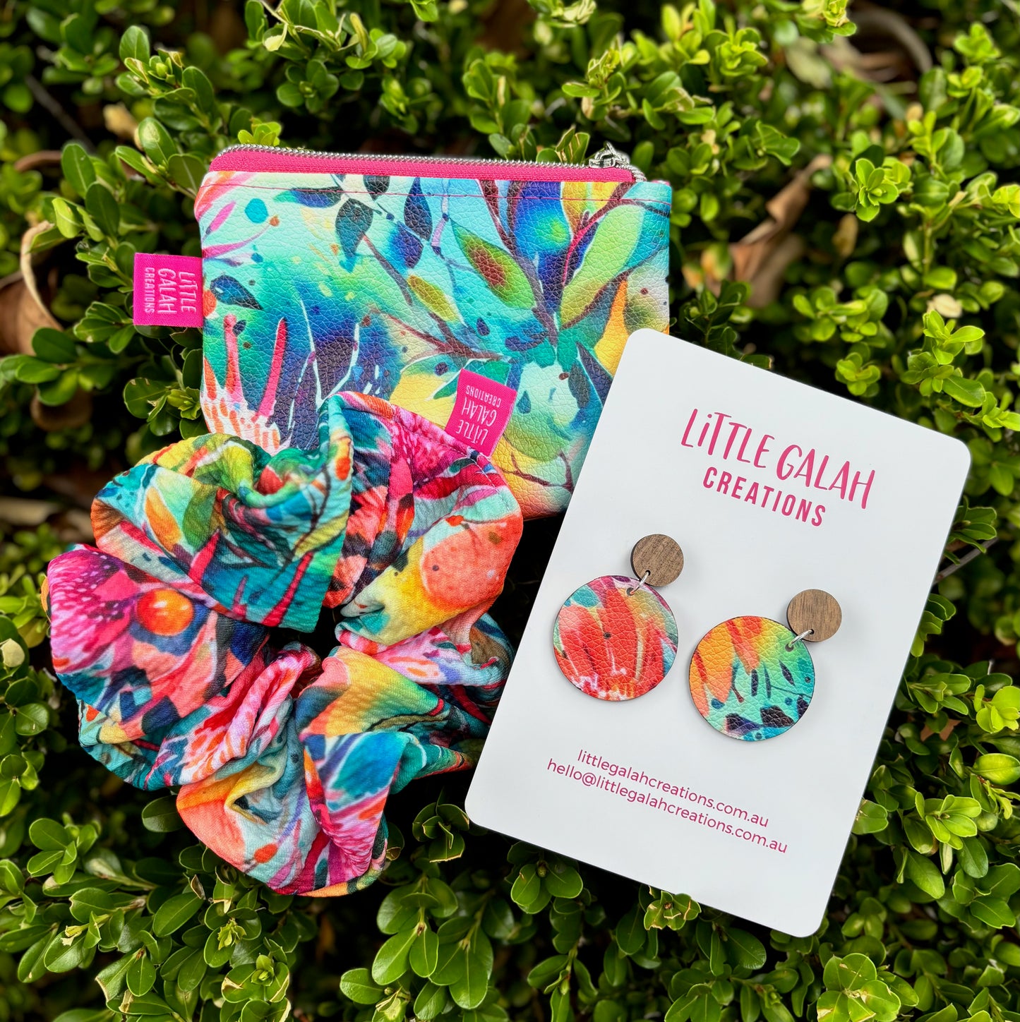 Colorful scrunchie, pouch, and earrings on a green leaf background