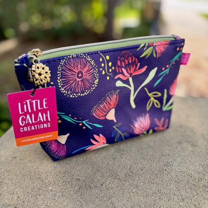 Floral-patterned pouch with 'Little Galah Creations' tag on a blurred natural background